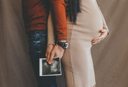 husband-and-wife-with-ultrasound-photo Father and Mother holding ultrasound of baby